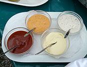 picture  showing  cups of edible sauces on platter